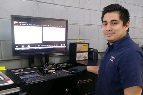 Mechanic Dervin using a computer, facing the camera
